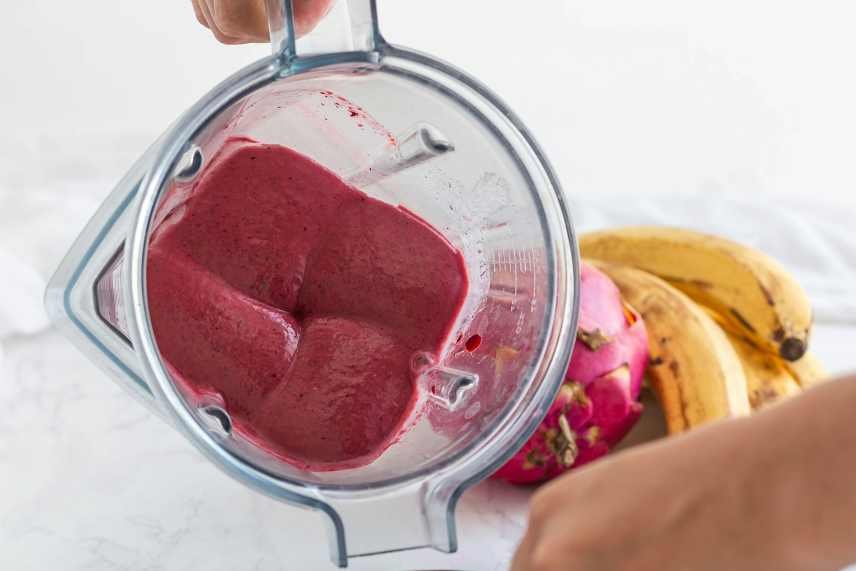 A close up of dragon fruit smoothie in a blender.