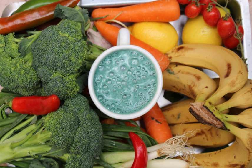 A smoothie surrounded by selected fruit and vegetables as these are known to be smoothie boosters