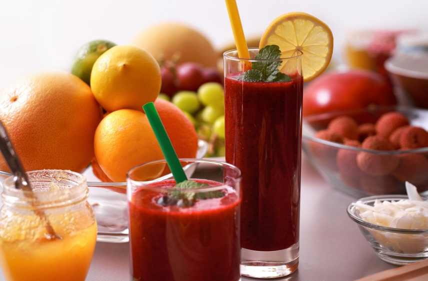 2 red berry smoothies and various ingredients that depict Benefits of Smoothies for Skin.