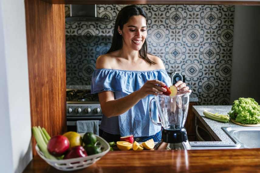 A Latin woman making Weight Loss Smoothies for Busy Women in her kitchen at home.