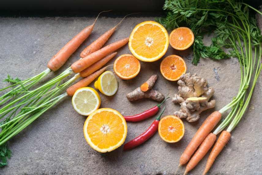 Image of ingredients for a Zesty Orange and Carrot Immunity Booster Smoothie - carrots, oranges, ginger. As well as lemons and red chilies.
