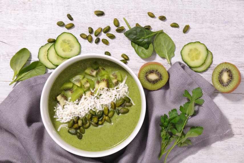 Vegan meal replacement smoothie bowl with spinach, kiwifruit, cucumber, celery, shredded coconut and pumpkin seeds.